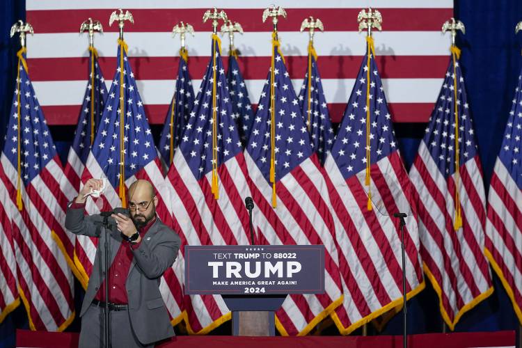 A member of the campaign on stage making the final adjustments on the teleprompter before the appearance of Republican presidential candidate former President Donald Trump at a caucus night party in Des Moines, Iowa, Monday, Jan. 15, 2024.(AP Photo/Pablo Martinez Monsivais)